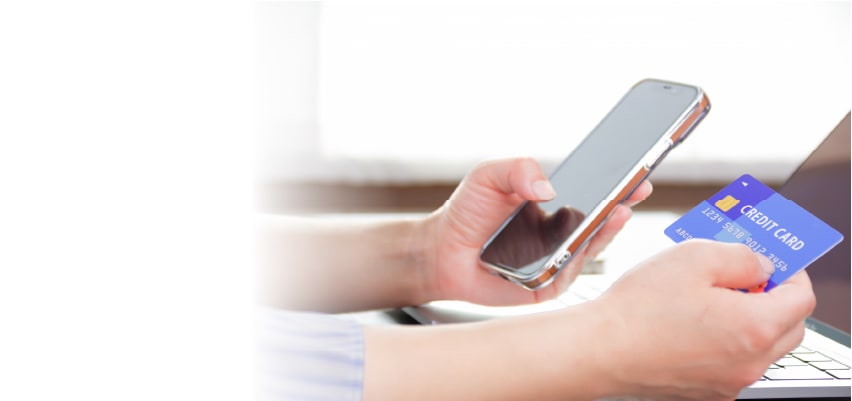 スマホとクレジットカードを手に取り現金化を行おうとする男性
